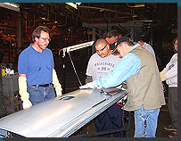 Instructor John Rademacher watches students as they practice filing techniques on a tailgate